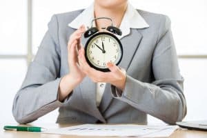 58383827 - business woman holding clock in office